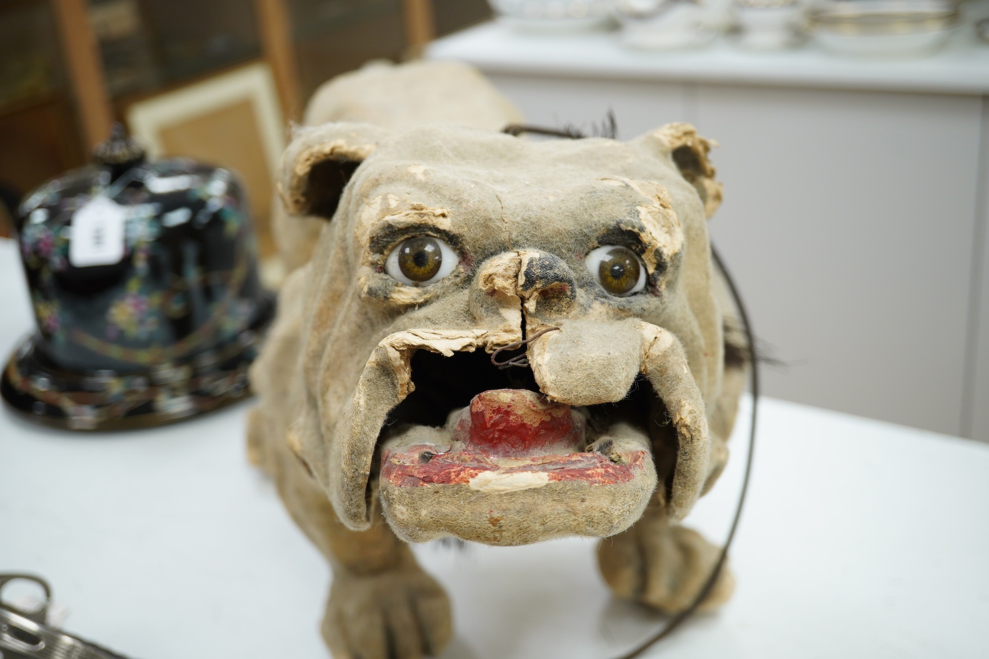 A French papier mache bulldog with bark effect, 66cm long, 35cm high. Condition - poor, some mis-shaping and part of muzzle, nose and ears missing